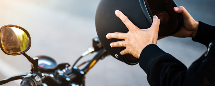 Man holding helmet preparing to mount motorcycle